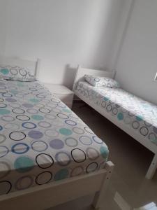 タンジェにあるAppartement neuf, lumineux et calme, entièrement meubléのベッドルーム1室(ベッド2台、水玉シーツ付)