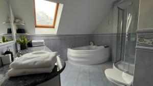 a bathroom with a tub and a toilet and a sink at Apartament Zamoście in Zamość +30 photos