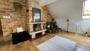 a living room with a brick wall and a fireplace at Apartament Zamoście in Zamość