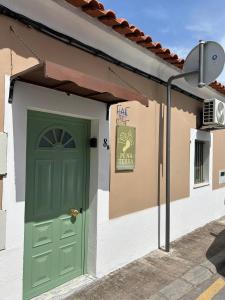 a green door on the side of a building at Pé na Terra Terraço in Reguengos de Monsaraz