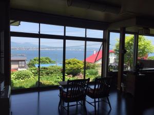 a dining room with a view of the water at Hakodateyama Guest House in Hakodate