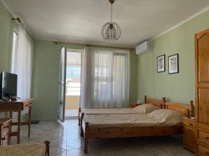 a bedroom with a bed and a desk and a window at KudevApartment1 in Nesebar
