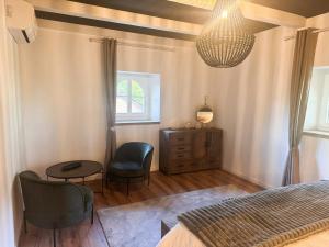 Un dormitorio con una cama, una mesa y una lámpara de araña. en Charming House Near Gondrexange Lake, en Jeuxey