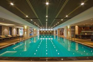 a large swimming pool with blue water in a hotel at Suzhou Qingshan Conference Center in Suzhou