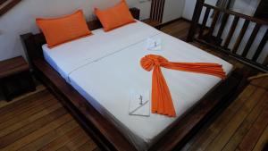 ein Bett mit einem orangenen Band darauf in der Unterkunft Khair Lodge Ambanja in Ambanja + 61 Fotos