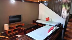 ein Zimmer mit zwei Betten und einem Flachbildfernseher in der Unterkunft Khair Lodge Ambanja in Ambanja