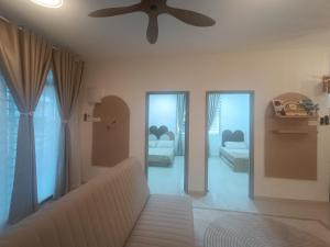 a living room with a couch and a ceiling fan at Ittizan homestay, Alor Gajah in Kampong Jelatang