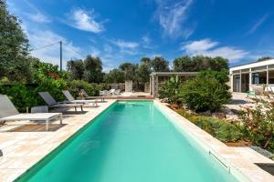 a swimming pool with blue water in a yard at Biancaluna Luxury Retreat by Perle di Puglia in Ostuni