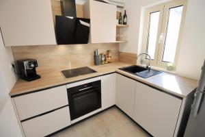 a small kitchen with white cabinets and a sink at Irina in Poreč