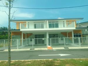 a house with a white fence in front of it at Ittizan homestay, Alor Gajah in Kampong Jelatang