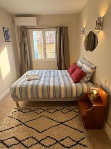 a bedroom with a bed with a window and a rug at La Petite Étoile d'Avignon in Avignon
