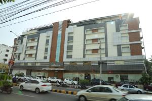 um grande edifício com carros estacionados em frente em Hotel Diamonds Pearl em Visakhapatnam