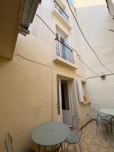 a patio with tables and chairs and a balcony at La Petite Étoile d'Avignon in Avignon