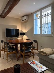 a living room with a table and chairs and a tv at La Petite Étoile d'Avignon in Avignon