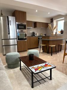 a kitchen and living room with a stainless steel refrigerator at La Petite Étoile d'Avignon in Avignon