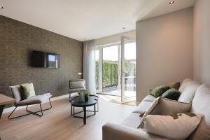 a living room with a couch and a tv at Heide Hoeve met Sauna & Hottub | 6 personen in Otterlo