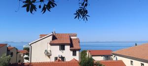 a building with red roofs and the ocean in the background at Holiday Home Drescher in Murter +16 photos