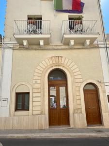a building with two doors and a balcony with a flag at Casa Festa Rooms in Matera