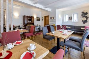 a dining room with tables and chairs and a kitchen at Bruckmayers Gästehaus in Pottenstein