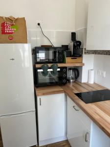 a kitchen with a microwave and a refrigerator at Le Rouet in Marseille