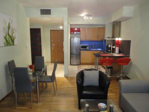 a living room with a table and chairs and a kitchen at Angel Plaza Krakow in Krakow