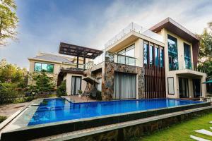 a house with a swimming pool in front of it at Flamingo dai lai resort - Hilltop H2 12 in Kon Rung (1)