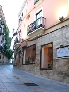 a stone building with windows and a street at Hotel Don Carlos Cáceres in Cáceres