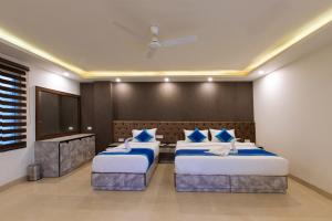 una camera da letto con due letti e una TV a schermo piatto di OPO VERTU Premium Delhi Aerocity a Nuova Delhi