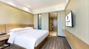 Postel nebo postele na pokoji v ubytování Borrman Hotel Xiamen Xiang'an Maxiang