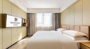 Postel nebo postele na pokoji v ubytování Borrman Hotel Xiamen Xiang'an Maxiang