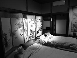a bedroom with two beds and paintings on the walls at Villa Shunten in Wada