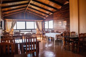 un comedor con mesas, sillas y ventanas en Hotel Venezia, en Golem