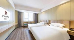 Postel nebo postele na pokoji v ubytování Borrman Hotel Xiamen Xiang'an Maxiang