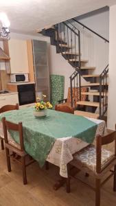 a dining room table with a green table cloth and chairs at Il Pioppo in Cantalupo nel Sannio