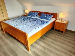 a bedroom with a large bed with blue pillows at Haus Leißner in Büsum