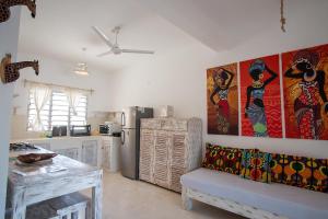 a kitchen with a refrigerator and a couch in a room at Fadhila Holidays in Watamu