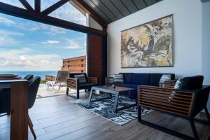 a living room with a blue couch and a large window at La Villa Bellevue in Petite Île