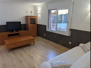 a living room with a tv and a couch at Winahost Apartment la Piscina de Creixell in Creixell