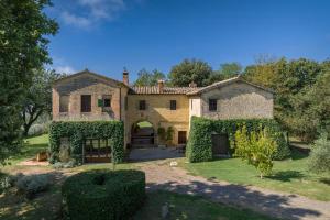 a large stone house with ivy growing on it at Tuscan Hamlet In Organic Wine Estate in Buonconvento