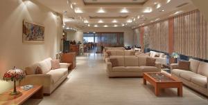 a waiting room with couches and tables in a lobby at Florida Blue Bay Resort & Spa in Psathopyrgos