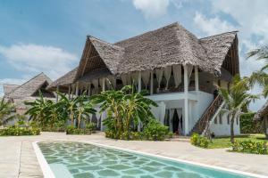 a villa with a swimming pool and a resort at Fadhila Holidays in Watamu