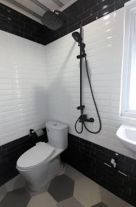 a black and white bathroom with a toilet and a shower at Zara Home Lembang in Padasul +19 photos