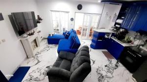 a living room with a blue couch and a marble floor at Zara Home Lembang in Padasul