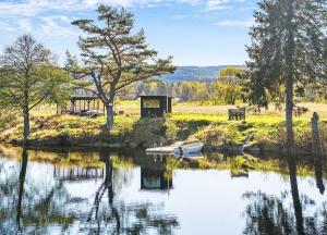 a small boat in the water next to a lake at Lovely Farmhouse By Nidelva With Sauna And Hot Tub in Åmli