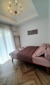 a bedroom with a large bed and a chandelier at Zara Home Lembang in Padasul