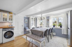 a kitchen and dining room with a table and chairs at Lovely Farmhouse By Nidelva With Sauna And Hot Tub in Åmli