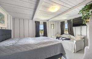 a bedroom with a bed and a couch and windows at Lovely Farmhouse By Nidelva With Sauna And Hot Tub in Åmli