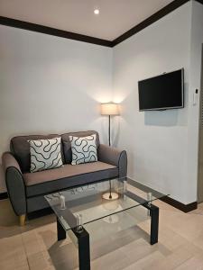 a living room with a couch and a tv on a wall at Bang Po Hut in Ban Bang Po