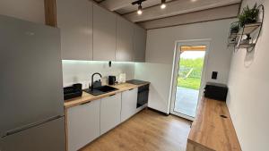 a kitchen with white cabinets and a counter top at Moonlight Houses z banią w cenie !!! in Wielki Podleś