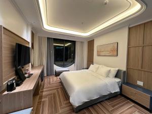 a bedroom with a bed and a flat screen tv at HN Apartment and Hotel in Tài Xá